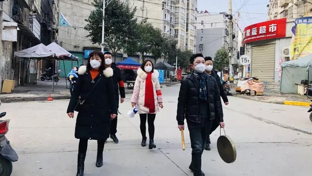 汉滨区江北办晏台村党支部书记、村委会主任胡万珍和班子成员沿着街巷一遍遍敲锣鸣示。.jpg