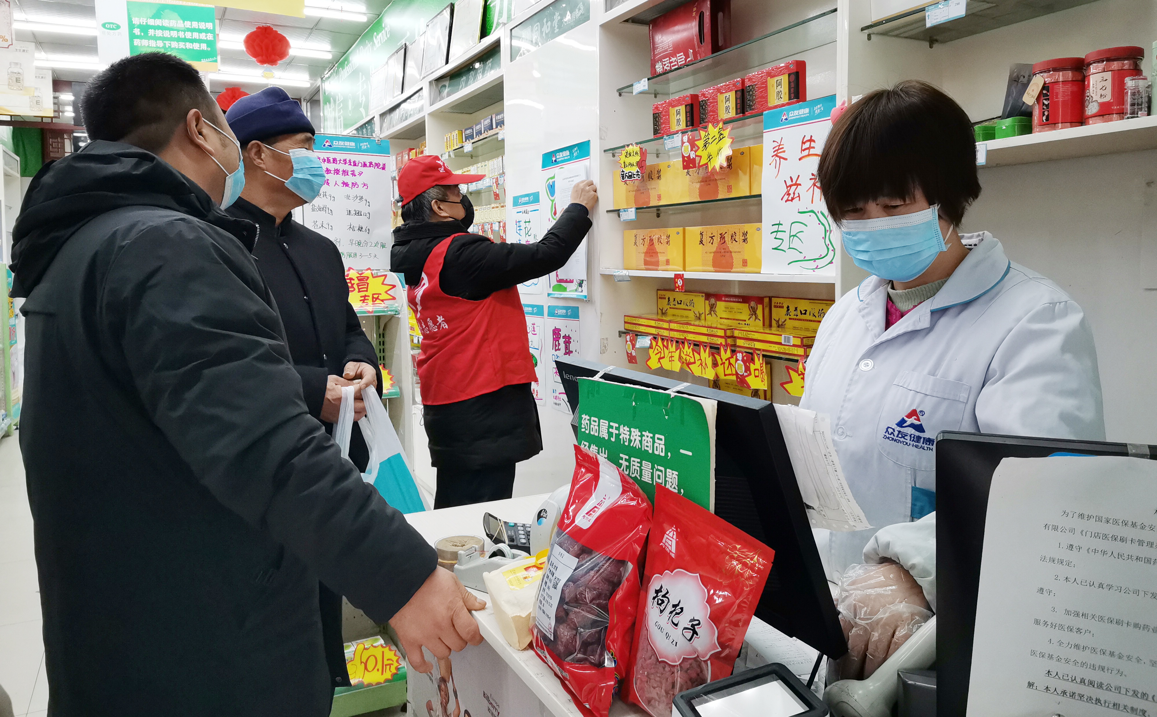 凤县市监局机关支部党员张培祥在药店张贴疫情防控通告.jpg
