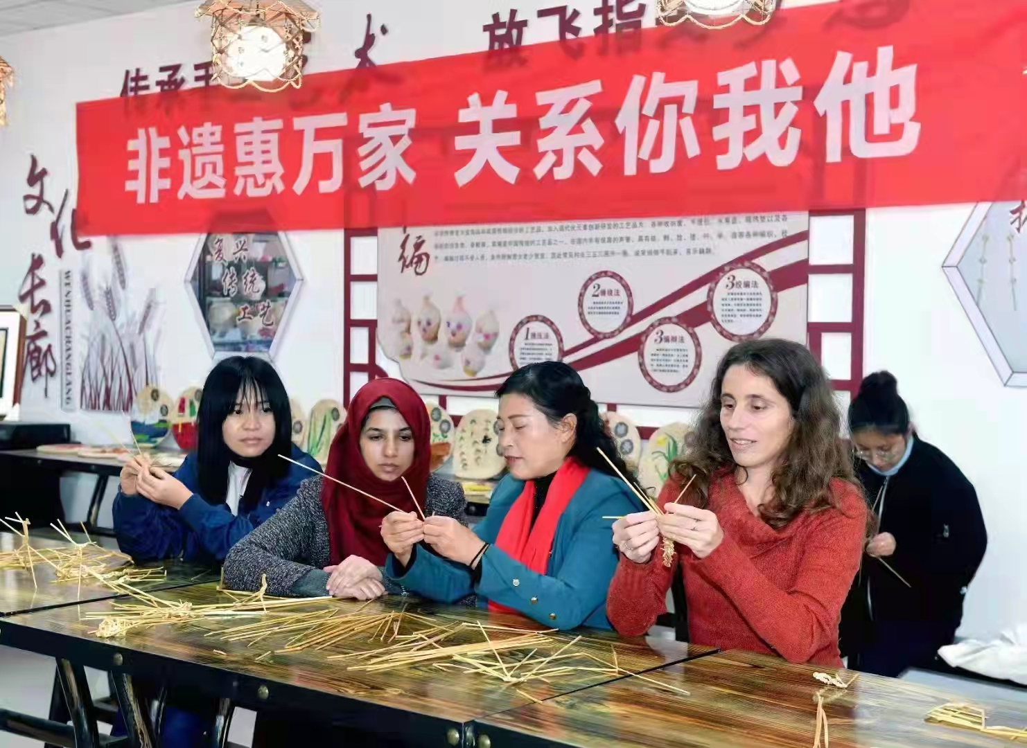 图2：临渭草编非遗项目传承人、巧娘草编合作社党组织书记陈春苗，在给外国友人教授草编技艺。.jpg